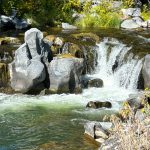 water cascades over a rock in a city park