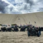 ATV riders waiting their turn to go up a sand dune